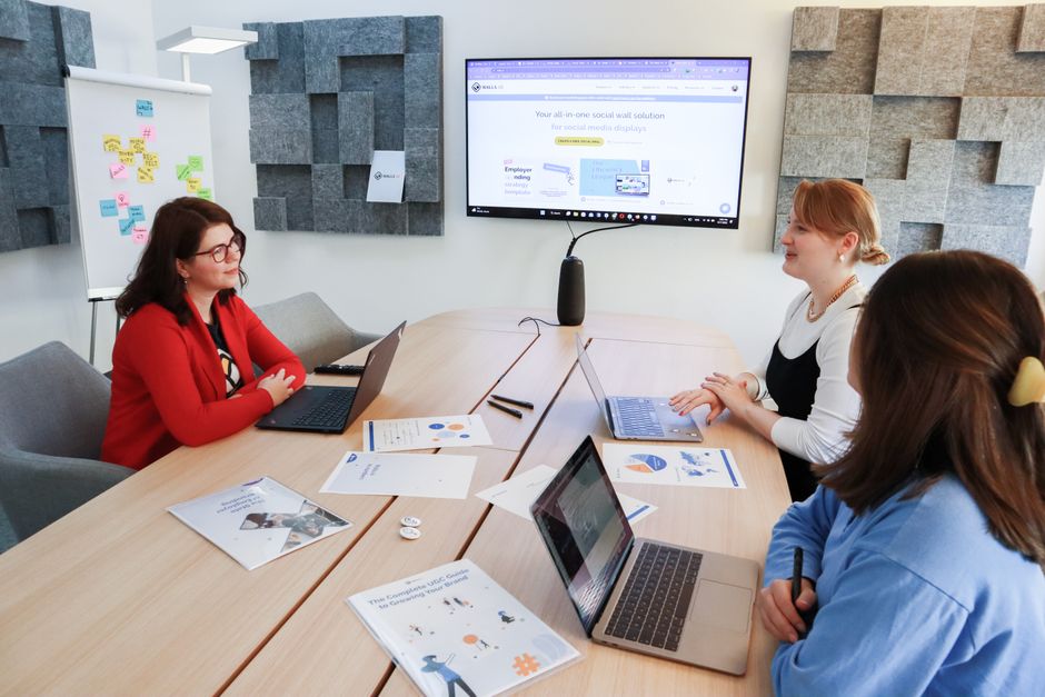 Business meeting with three women discussing strategije koristeći laptope i prezentacije u modernom uredu
