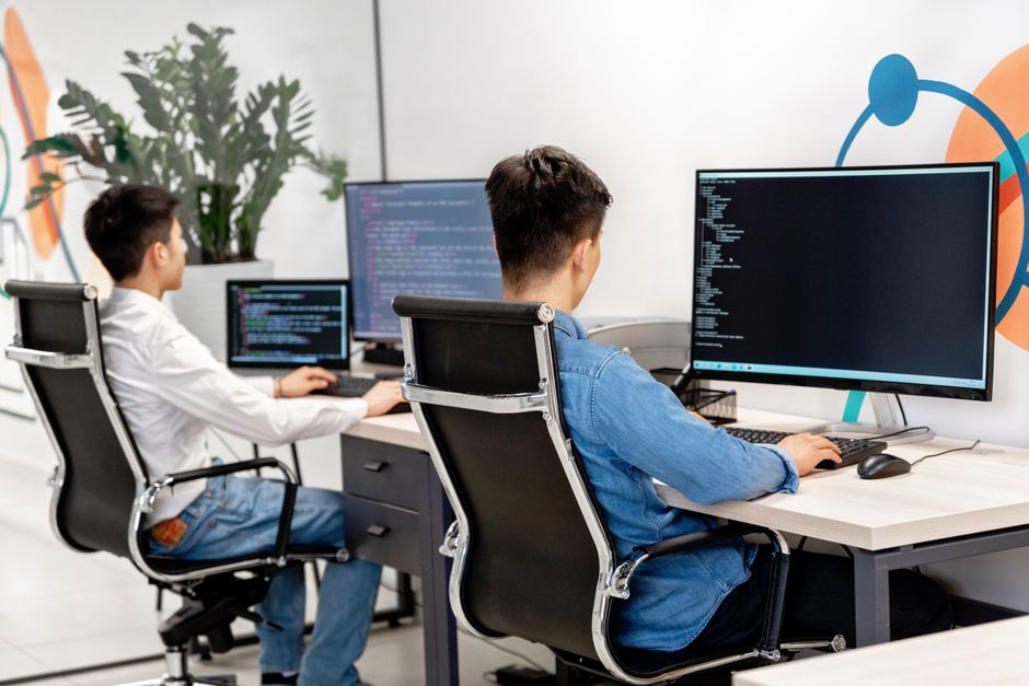 Dva programera rade na izradi ERP sustava u modernom uredu